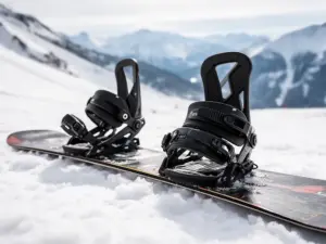 Wiązania snowboardowe na desce leżącej na śniegu, do których mocuje się buty snowboardowe podczas jazdy