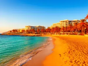 Cypr listopad all inclusive - piaszczysta plaża i lazurowe morze przy luksusowym hotelu na Cyprze jesienią