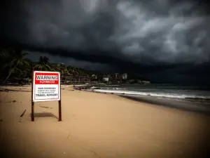 Opuszczona plaża z chmurami burzowymi symbolizująca miejsca gdzie nie jechać na wakacje 2026 ze względów bezpieczeństwa