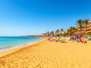 Hiszpania gdzie na wakacje z dziećmi - piaszczysta plaża z spokojnym morzem i atrakcjami dla najmłodszych na Costa Dorada