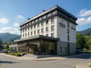 Hotel Beskid w Nowym Sączu - widok na budynek hotelu z panoramą Beskidów w tle