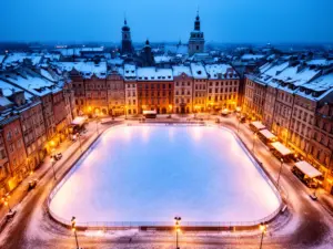 Lodowisko Kraków - widok z lotu ptaka na oświetloną taflę lodowiska w centrum miasta zimą