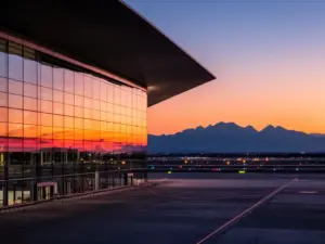 Lotnisko Kraków-Balice – widok na nowoczesny terminal pasażerski z charakterystyczną szklaną fasadą o zmierzchu