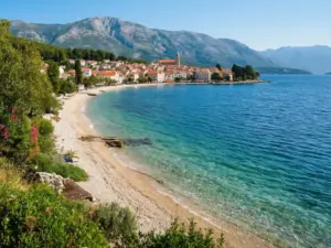 Orebić Chorwacja - widok na plażę żwirową i Morze Adriatyckie z górą Sveti Ilija w tle