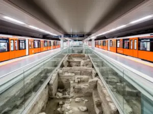 Nowoczesna stacja rzym metro z widocznymi starożytnymi ruinami archeologicznymi za szklanymi panelami