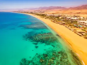 Sharm el sheikh wakacje - widok na turkusowe wody Morza Czerwonego i piaszczystą plażę z rafami koralowymi