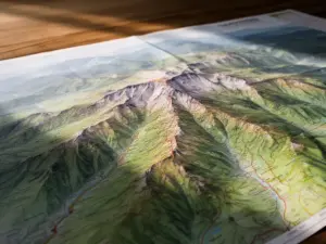 Szczegółowa sudety mapa turystyczna z zaznaczonymi szlakami górskimi i szczytami rozłożona na stole