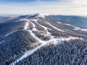 Świeradów-Zdrój atrakcje - panorama Gór Izerskich ze stokami narciarskimi i szlakami turystycznymi w tle zielonych lasów