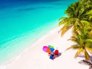 Tropikalna plaża z bagażem i parasolem – symbol bezpiecznych wakacji z ubezpieczeniem na wakacje