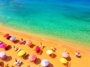 Plaża nad morzem idealna na wakacje last minute sierpień 2026 z turkusową wodą i złotym piaskiem