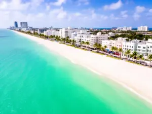 Wakacje Miami - widok na plażę South Beach z turkusowym oceanem i palmami wzdłuż wybrzeża Florydy